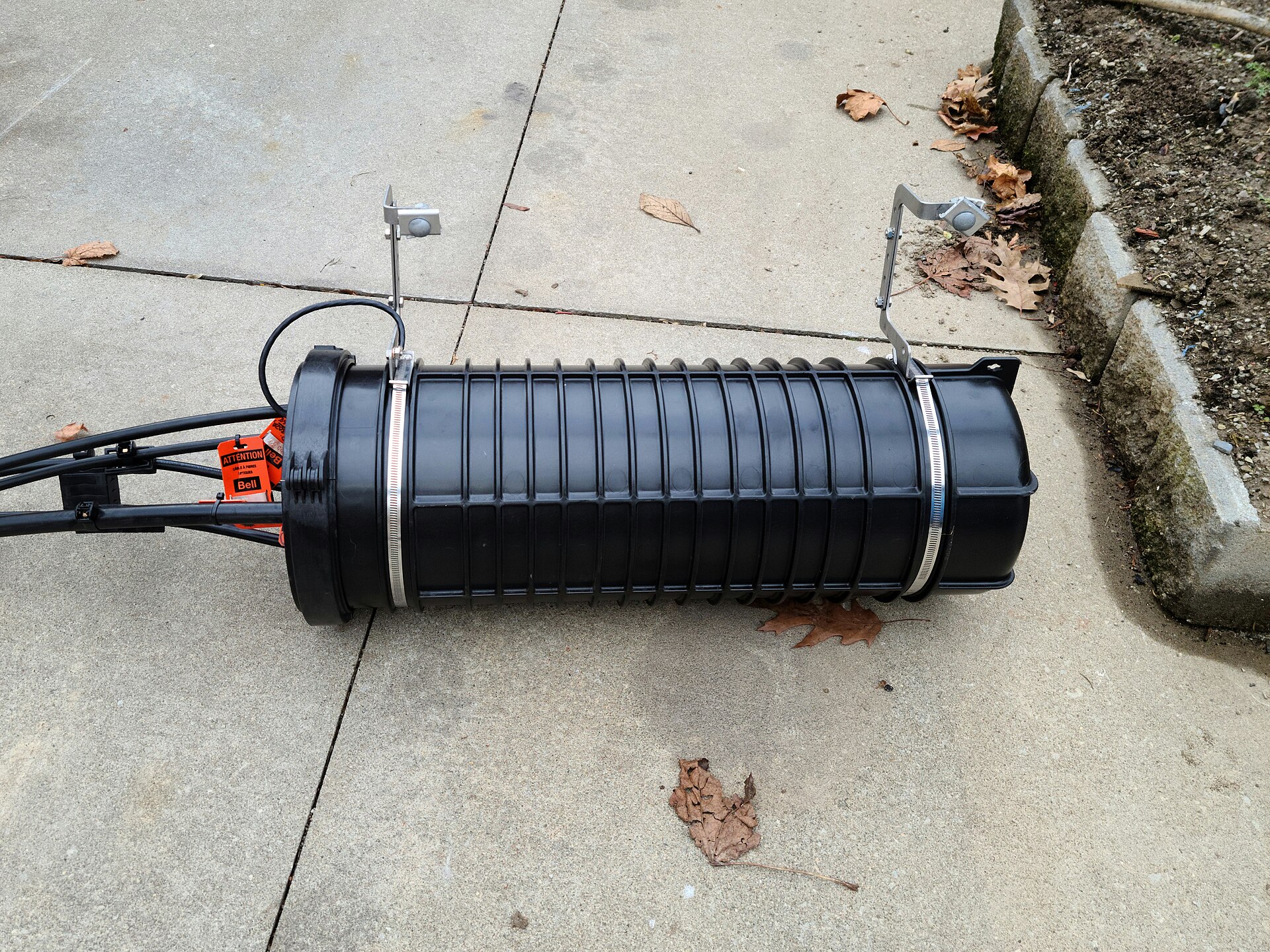 Aerial fiber optic splice enclosure mounted on a utility pole